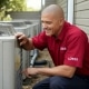 Man inspecting air conditioning unit in Topeka, KS